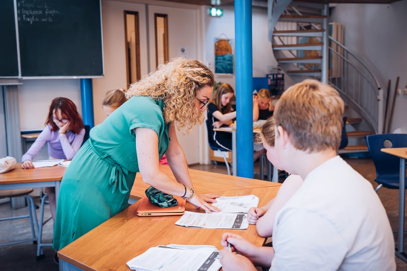 leerkracht coacht leerlingen tijdens begrijpend lezen door ze te ondersteunen bij het stellen van tekstgerichte vragen